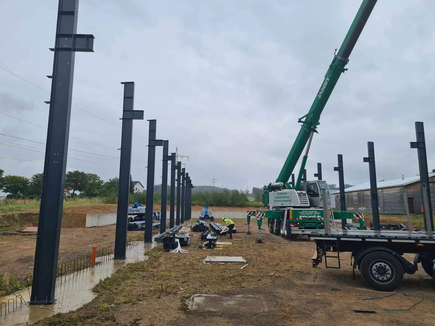 Steel columns and a mobile crane on the E-Device building site