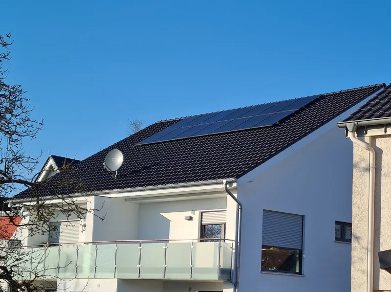 Haus mit PV unter blauem Himmel