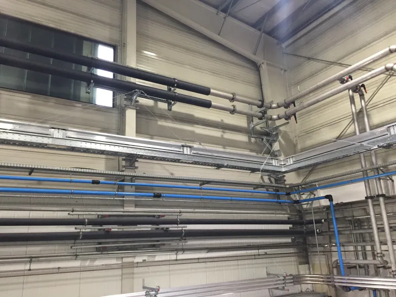 Cable trays and pipes along the hall wall