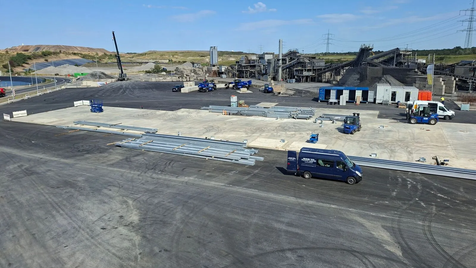 Site of the new bottom ash plant with steel parts on the new foundation, the existing plant behind