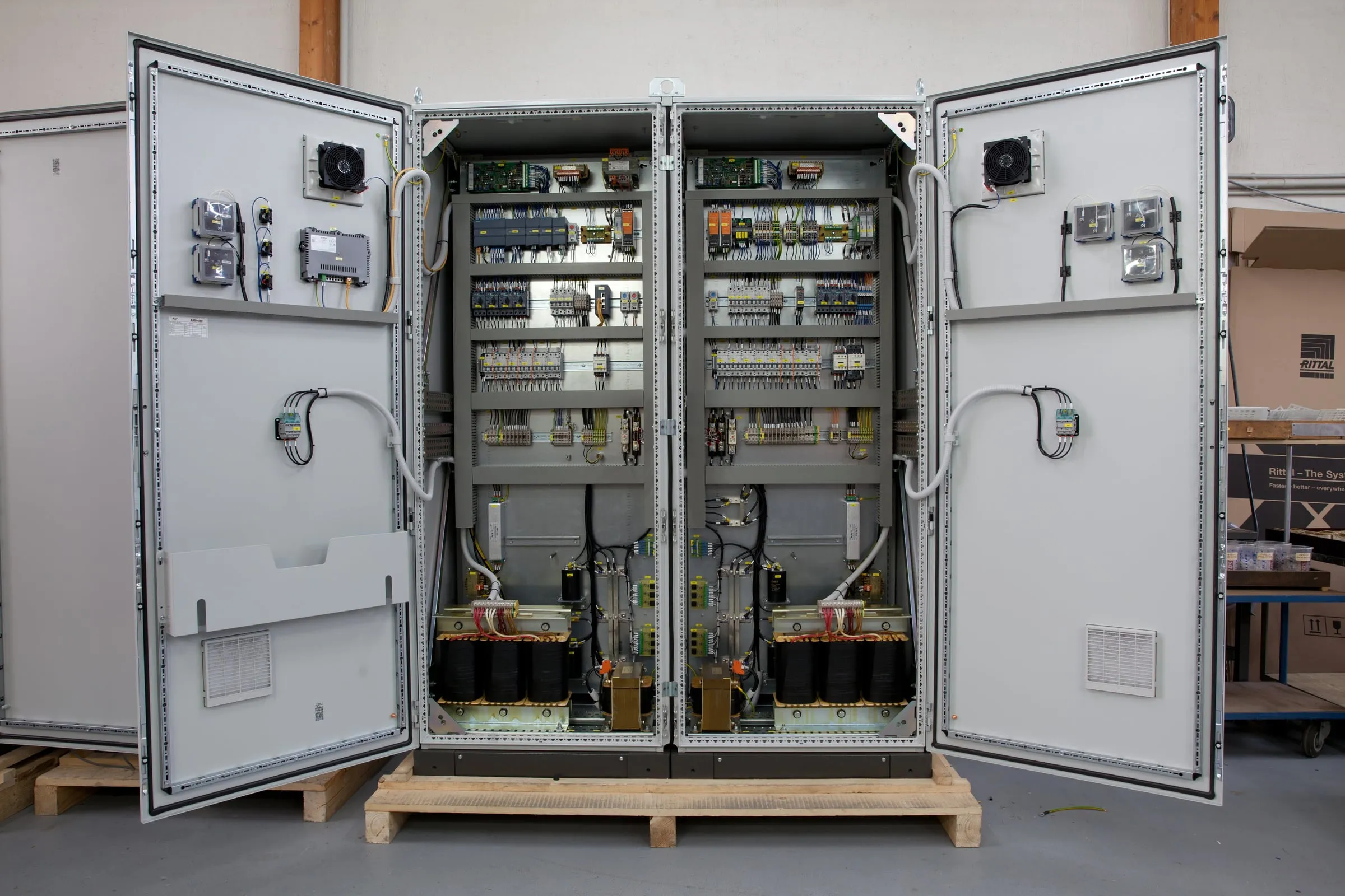 Open double cabinet of a DC power supply with transformers